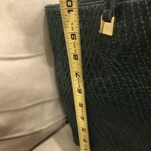 Green Ivanka Trump leather bag, peeling on side of bag.  Not that noticeable.